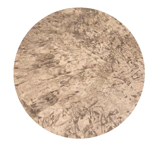 A close-up image of a circular, textured stone or concrete surface with a rough, mottled appearance.