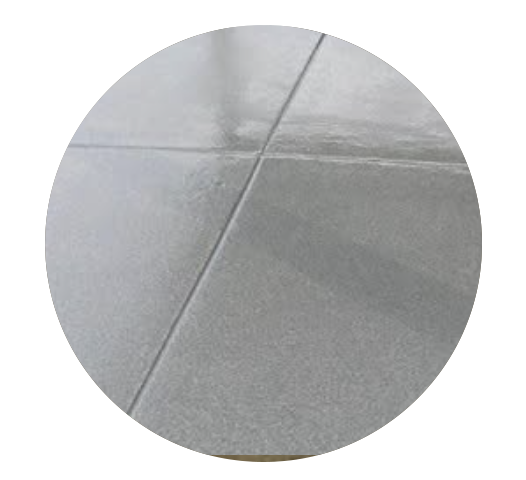 Close-up of light gray tiled floor with visible grout lines.