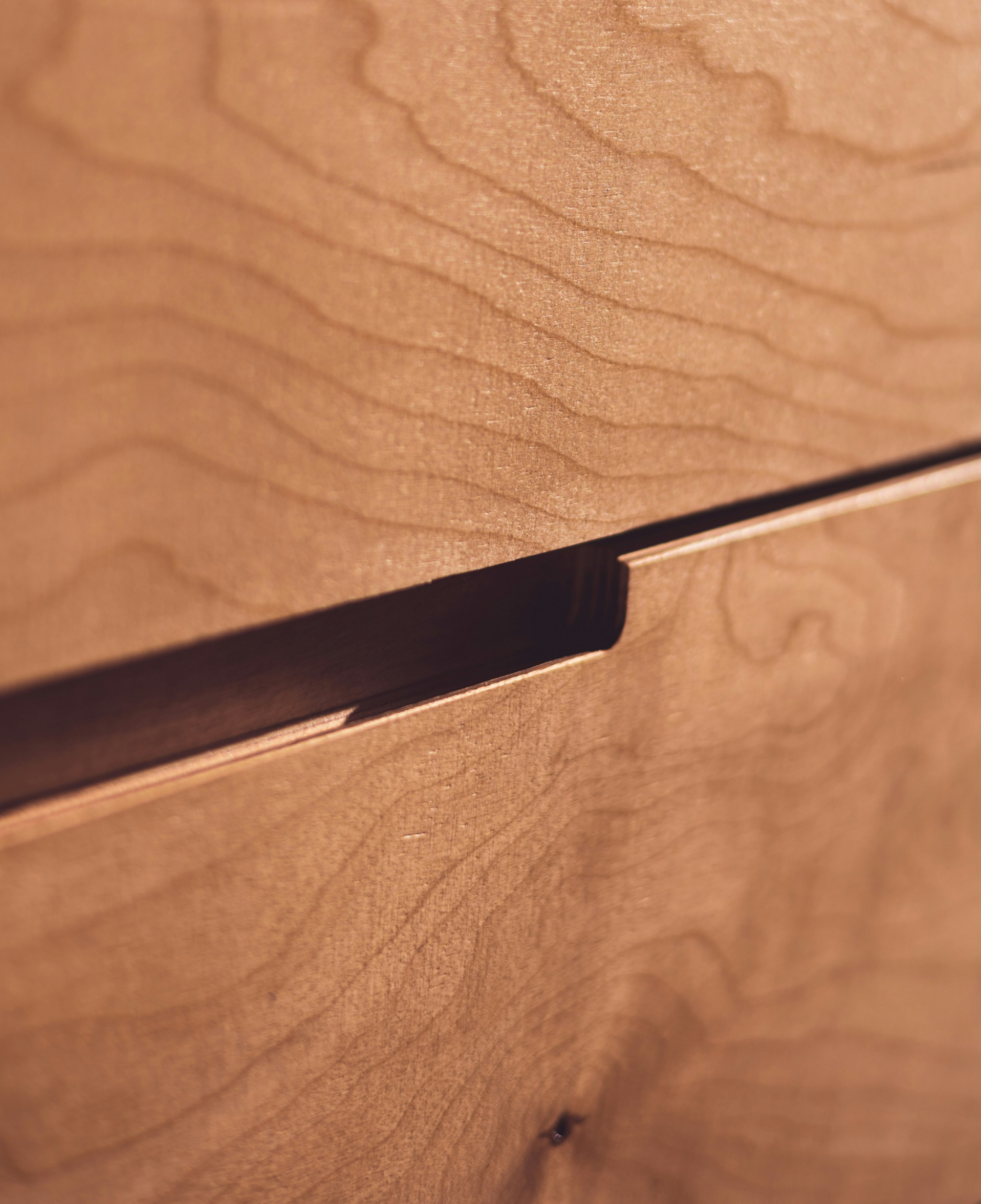 Close-up of natural wood grain and a recessed handle detail.