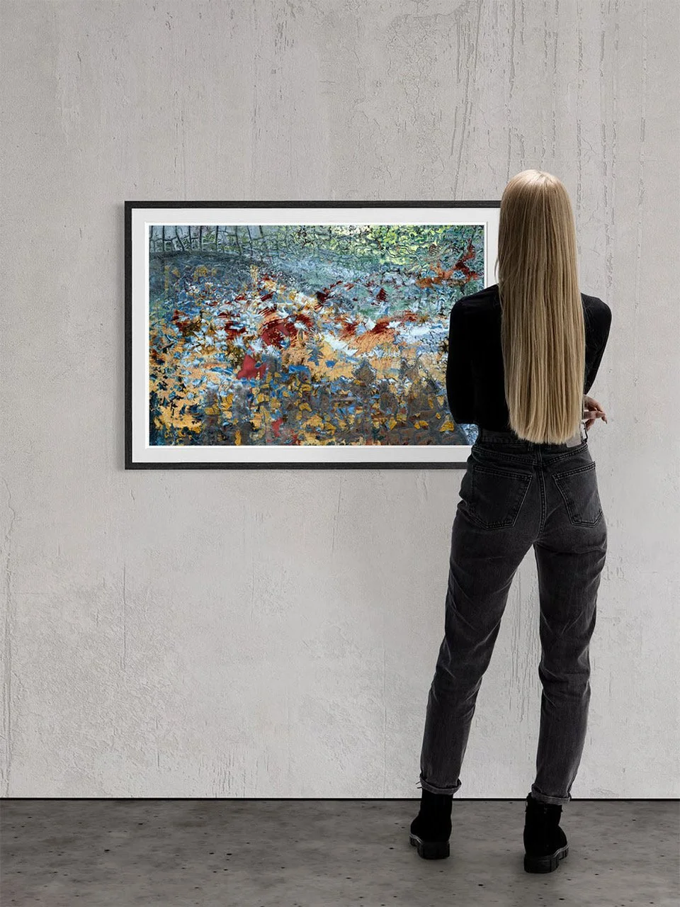 A woman with long blonde hair, wearing a black top and black jeans, stands with her arms crossed while looking at an abstract painting in an art gallery.