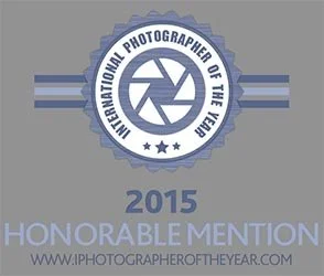 Certification badge with camera shutter icon and blue and gray color scheme, labeled '2015 Honorable Mention' from International Photographer of the Year.