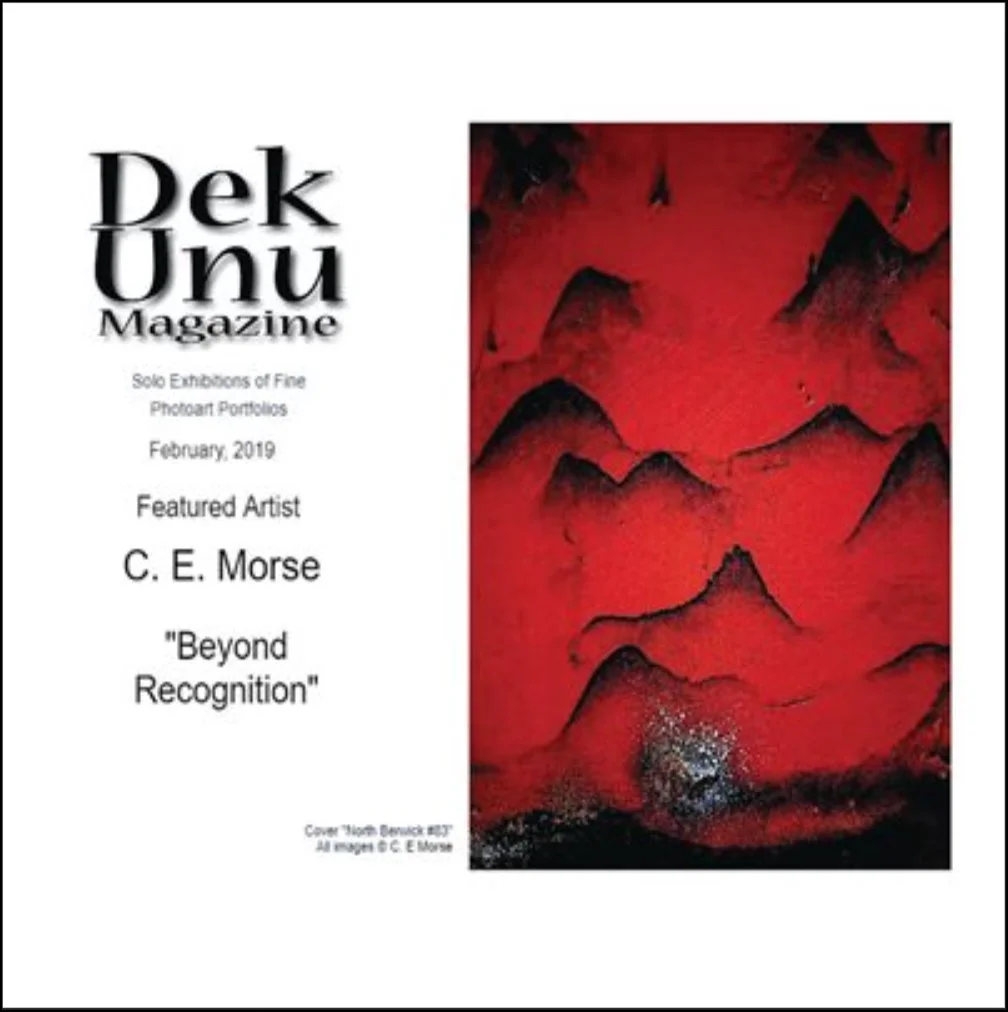 Cover of Dek Unu Magazine February 2019 featuring a red and black abstract painting of mountains and a textured landscape.