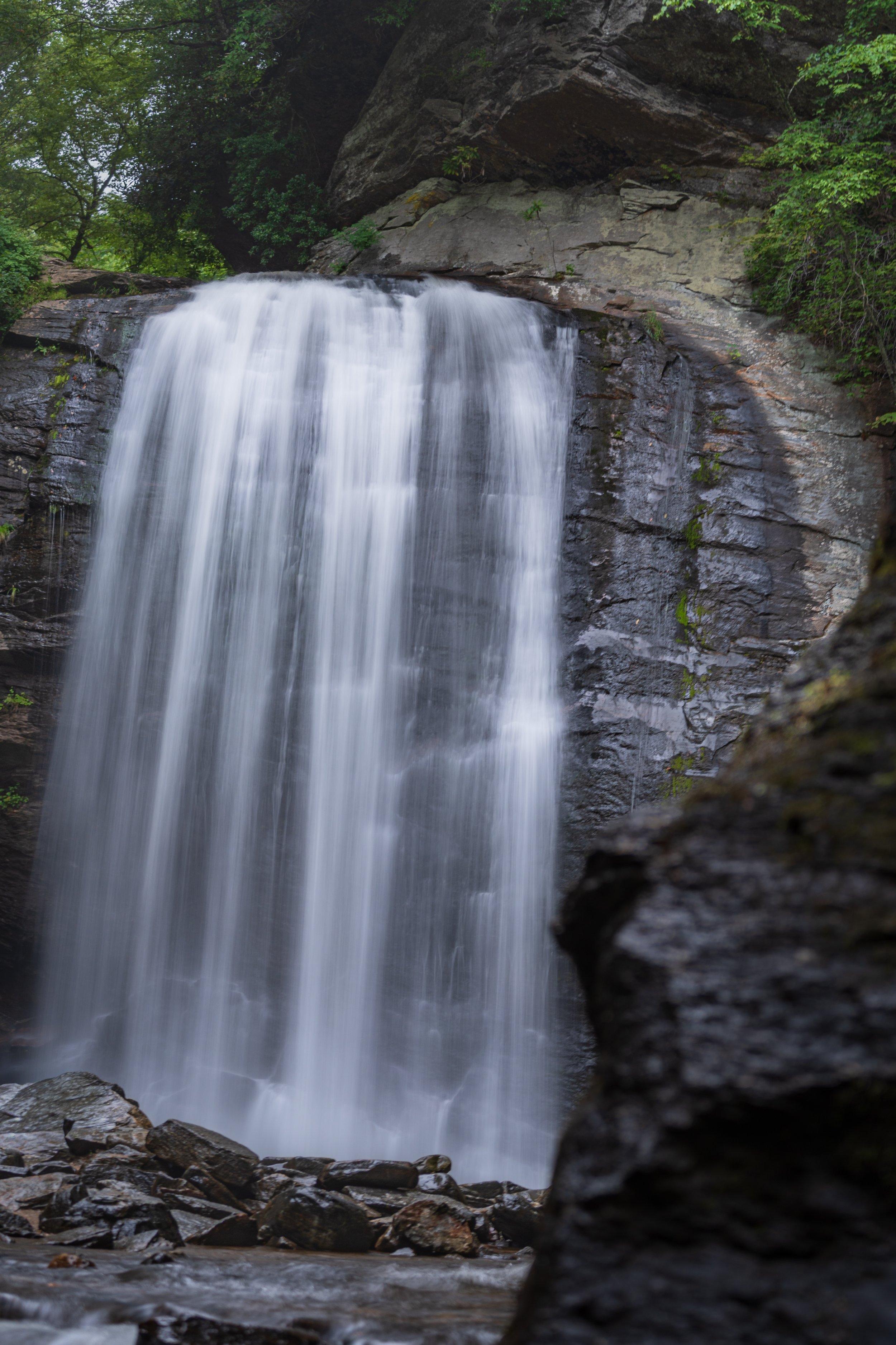 Looking Glass Falls flowing over rock surrounded by the forest in Pisgah National Forest, North Carolina.