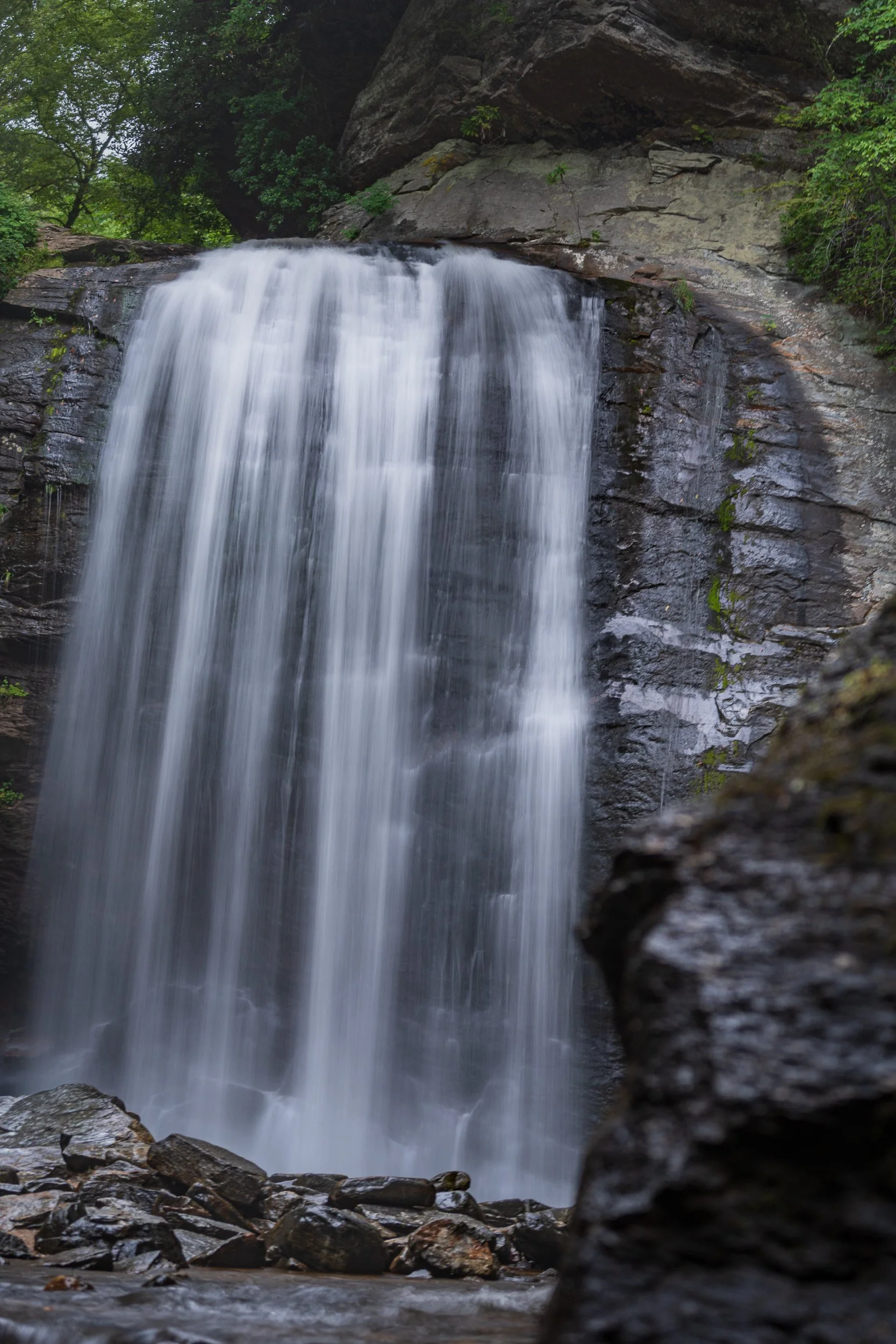 Looking Glass Falls flowing over rock surrounded by the forest in Pisgah National Forest, North Carolina.