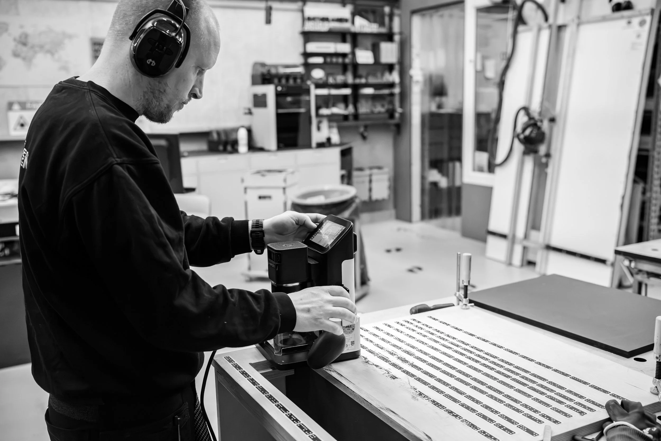 Mand arbejder med elektronisk udstyr i et værksted.
