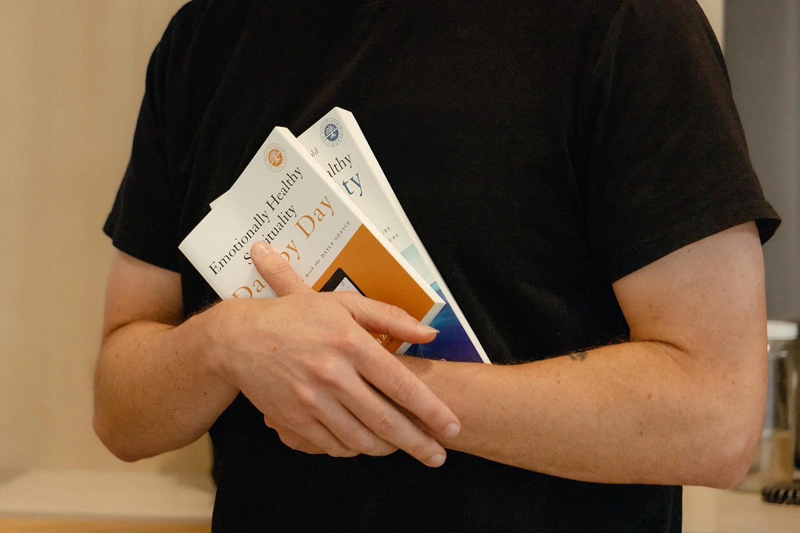 Person holding two books titled 'Emotionally Healthy Spirituality' and 'Emotionally Healthy Spirituality Day-by-Day'.