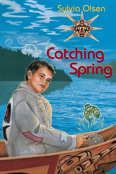 Book cover for Sylvia Olsen's 'Catching Spring,' featuring a boy in a canoe on a lake, with a stylized sun and a green frog in the water, and forested hills in the background.