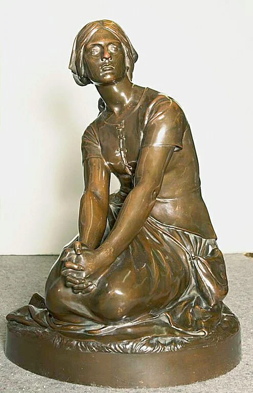 Cast statue of a kneeling woman