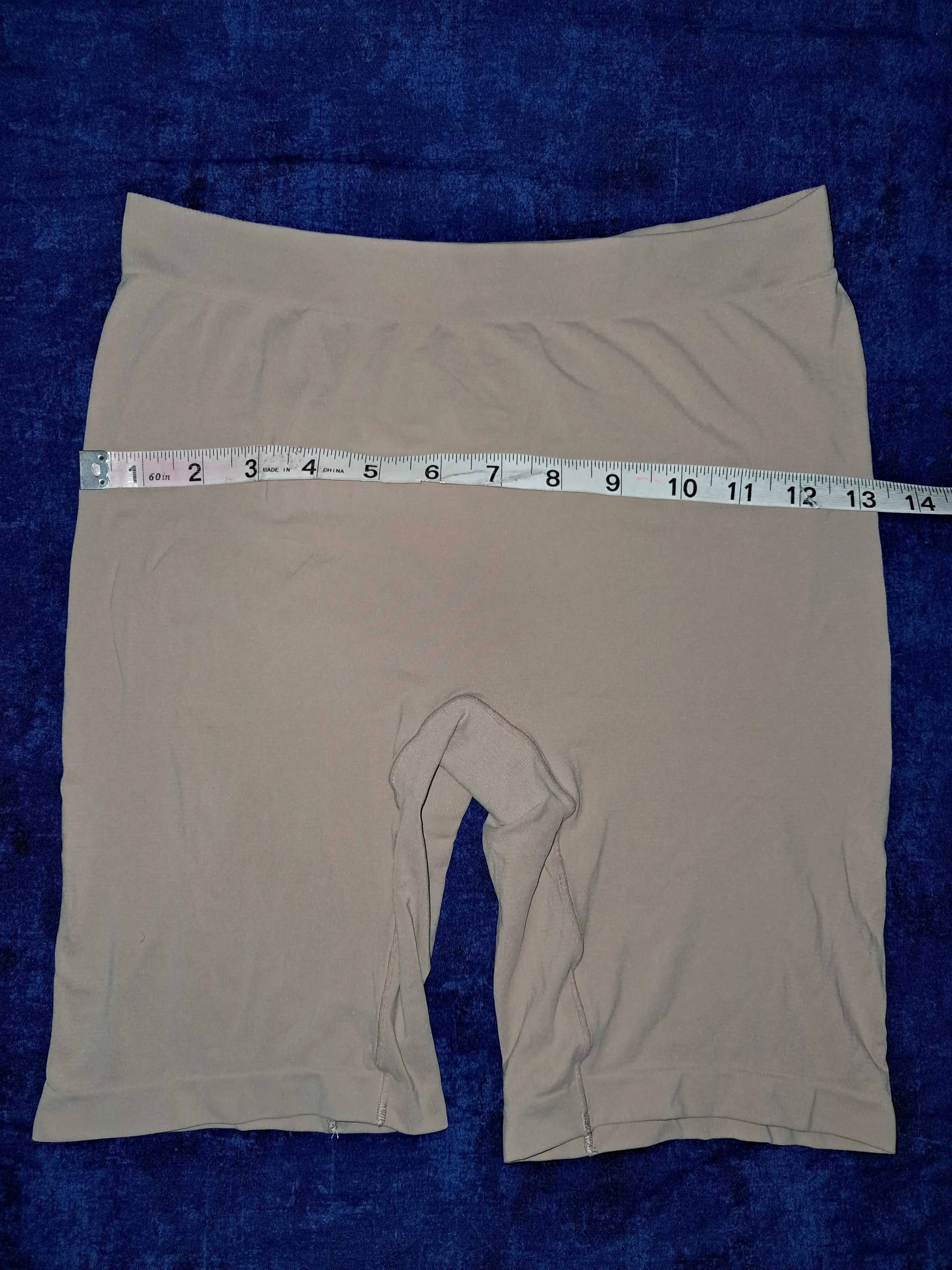 Beige Thigh Society anti-chafe cooling shorts on a blue background