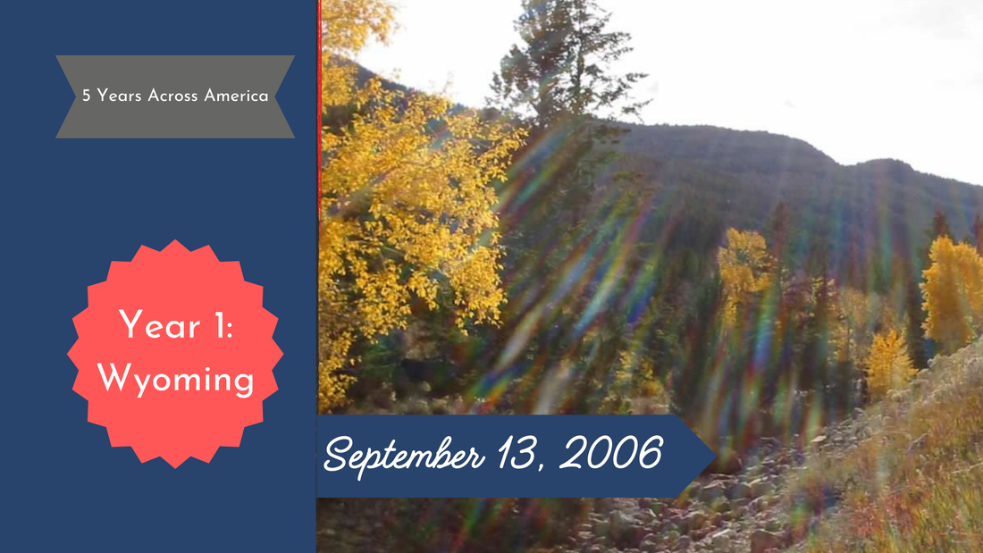 Sun streaks across evergreen hills and yellow aspens