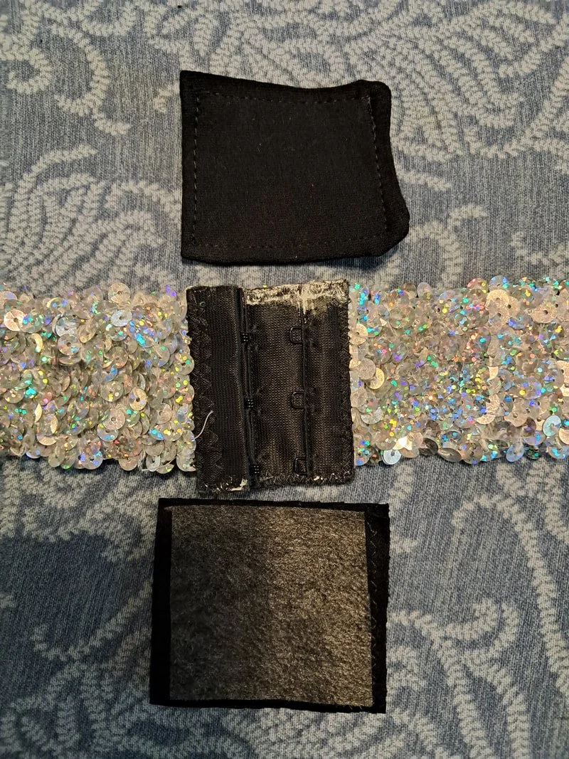Silver sequin belt with black closure with black fabric rectangle placed above and below