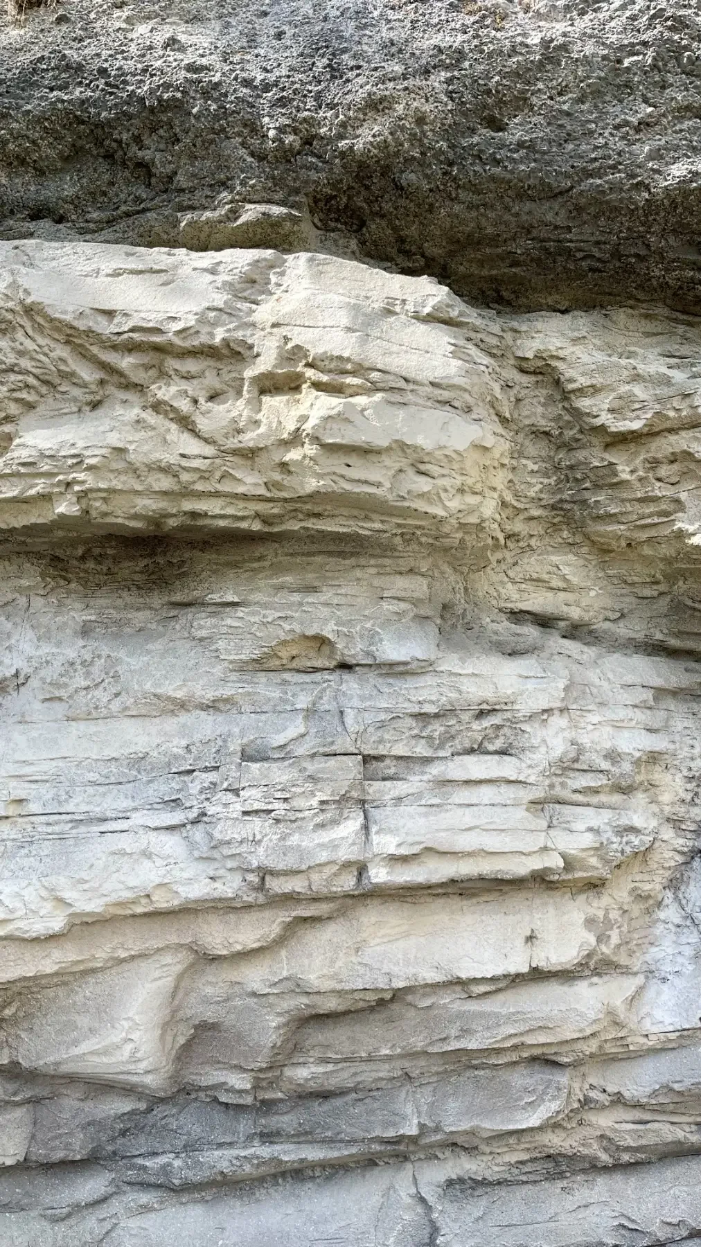Detail der rekonstruierten Felswand am Gubelstein mit hellen, horizontal verlaufenden Gesteinsschichten, Bruchkanten und dem Übergang zur dunkleren Felsformation darüber.