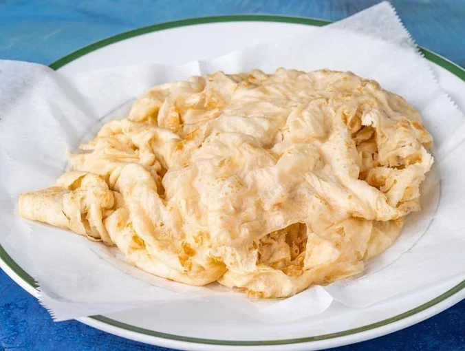 Fried catfish fillet on a paper-lined plate.