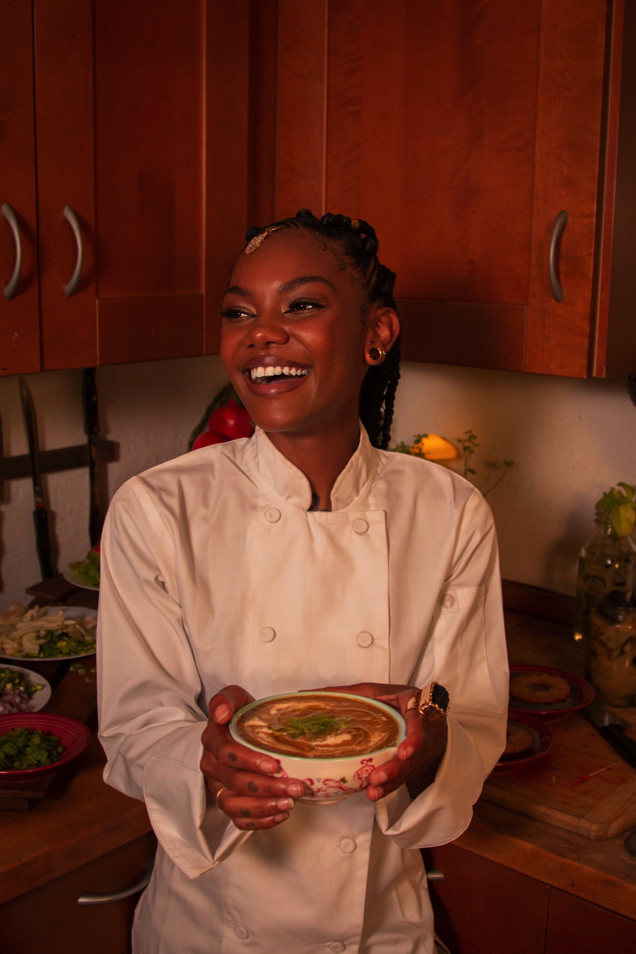 Chef Cole Lawson wearing a chef's jacket and holding a soup dish