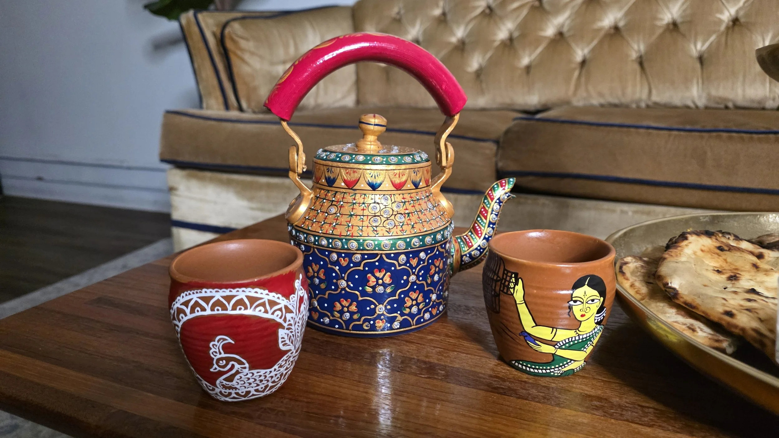 Luxe Tea product photo depicting ornate hand painted teapot and clay cups