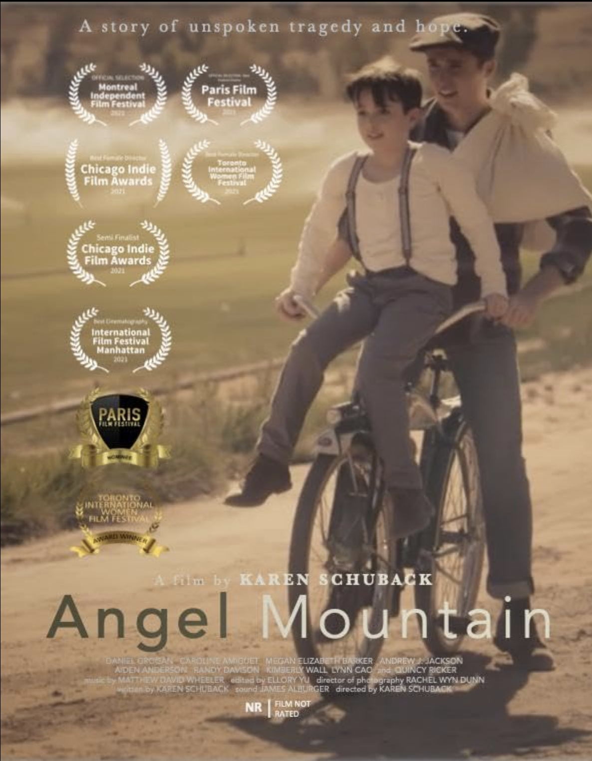 Movie poster for 'Angel Mountain' by Karen Schuback, featuring two boys riding a bicycle on a dirt path with an open field background, surrounded by film festival awards and selections.