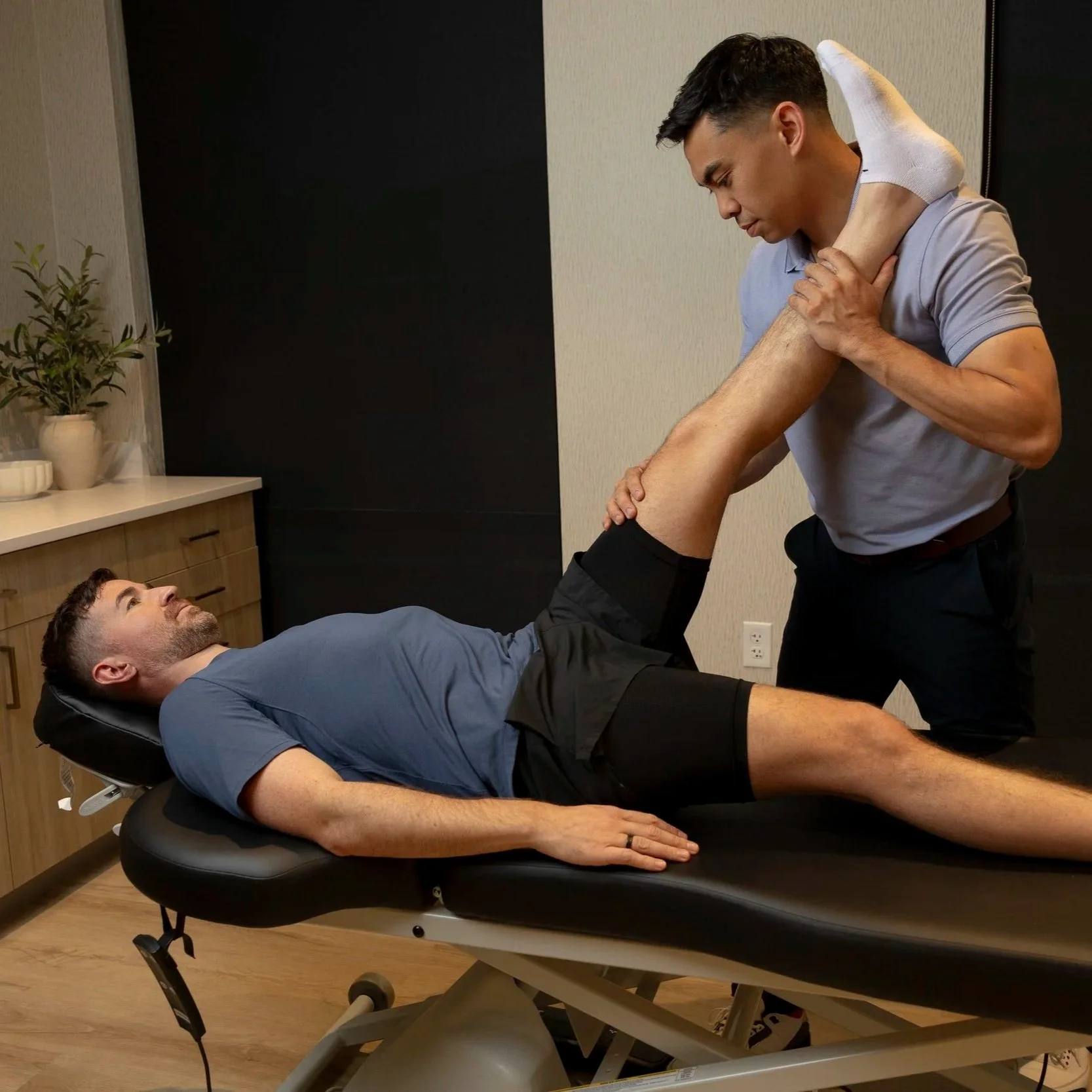 physical therapist performing assisted leg stretching with a patient at Estetica Wellness in Las Vegas