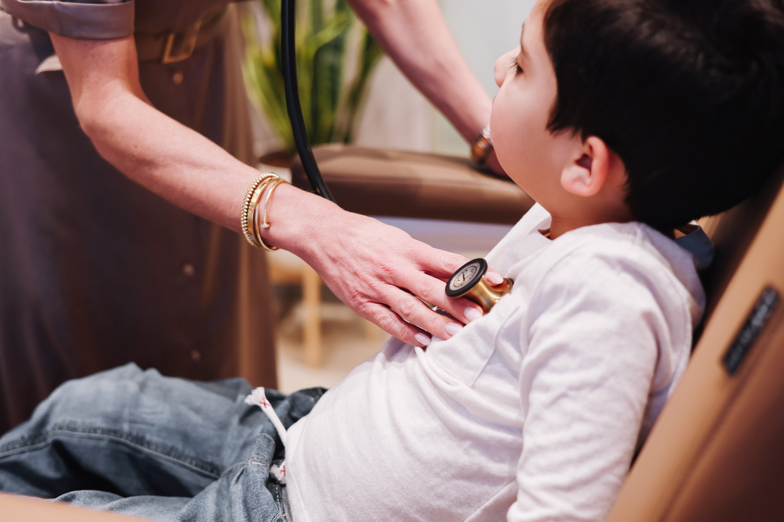 Dr. Lisa Zia using a stethoscope during a personalized pediatric wellness exam at Estetica Wellness in Las Vegas