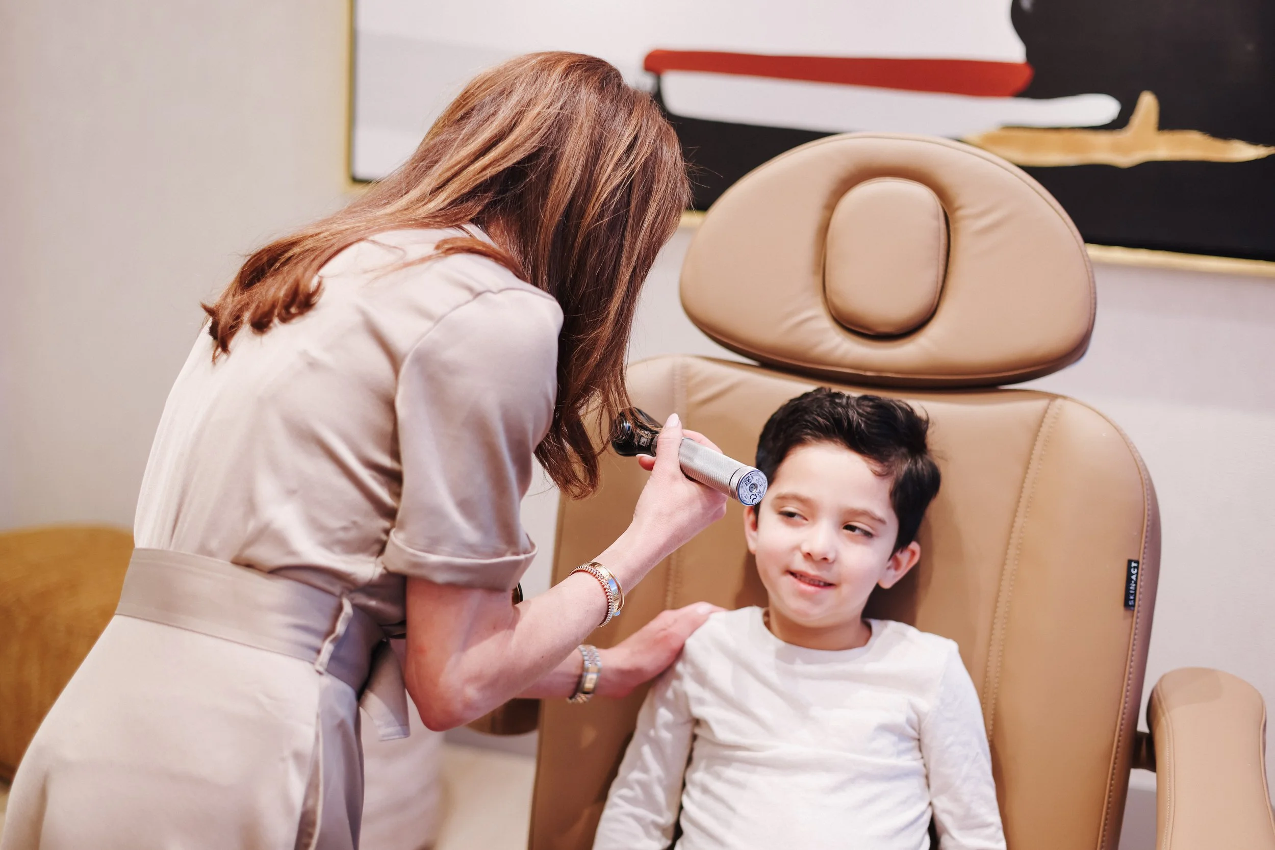 Dr. Lisa Zia, Pediatrician performing an ear exam during a concierge pediatric visit at Estetica Wellness in Las Vegas