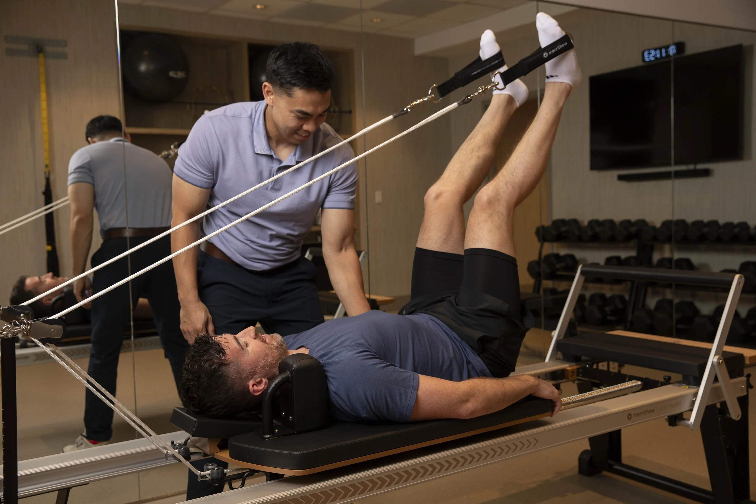 physical therapist guiding a patient with Pilates reformer exercise at Estetica Wellness in Las Vegas