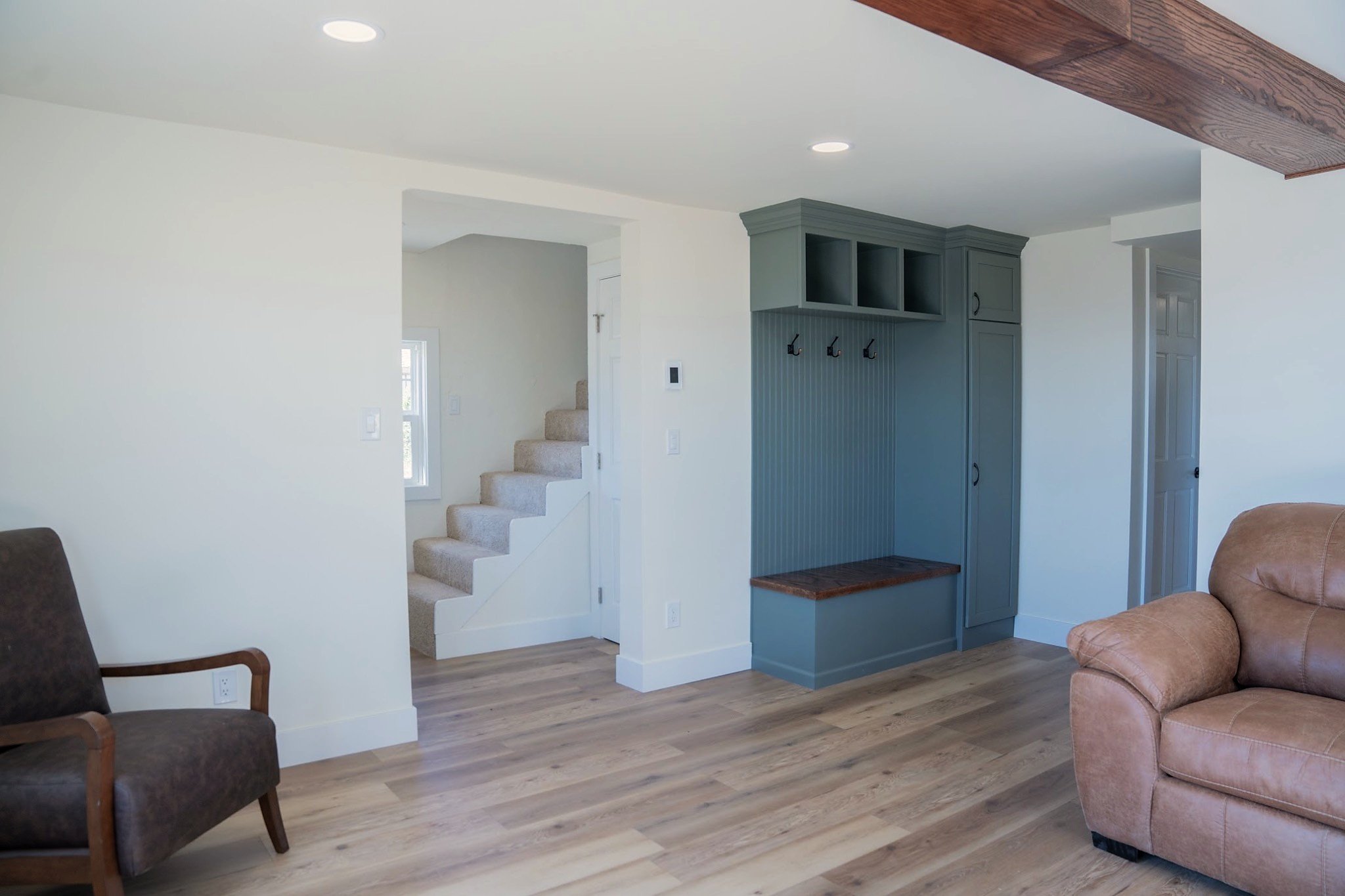 Renewed cabin living area with new flooring, trim, paint, and a custom mudroom built-in.