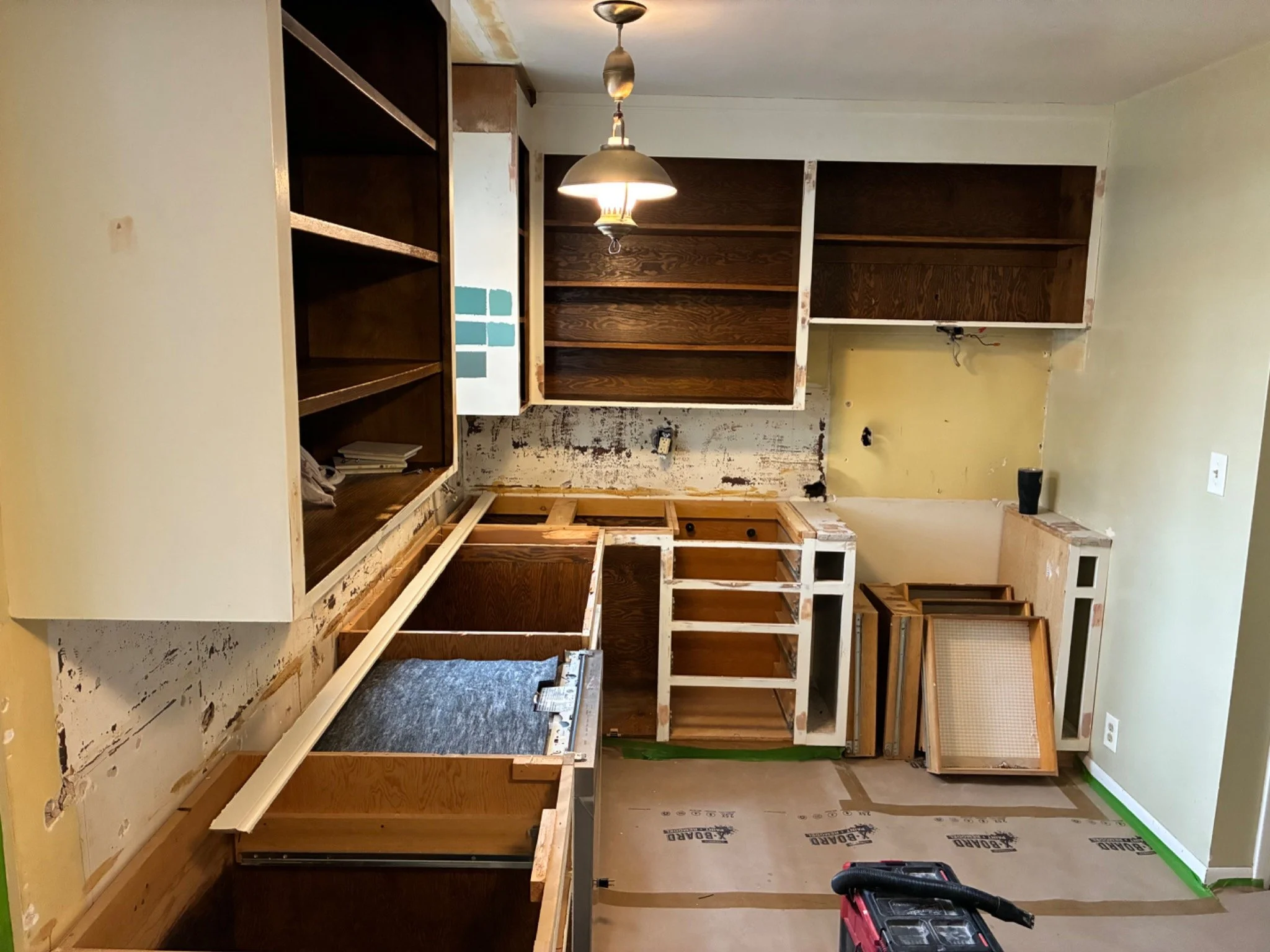 During: Existing cabinet boxes retained and prepared for refurbishment after doors and countertops were removed.