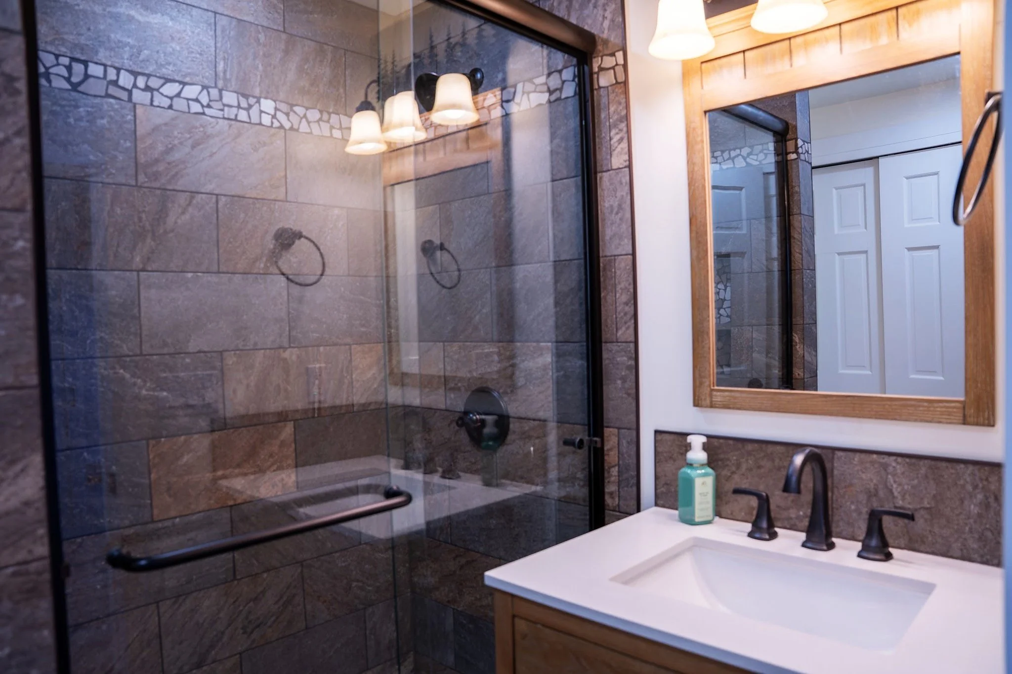 Custom tiled shower with glass enclosure, new vanity, fixtures, and coordinated bathroom finishes.