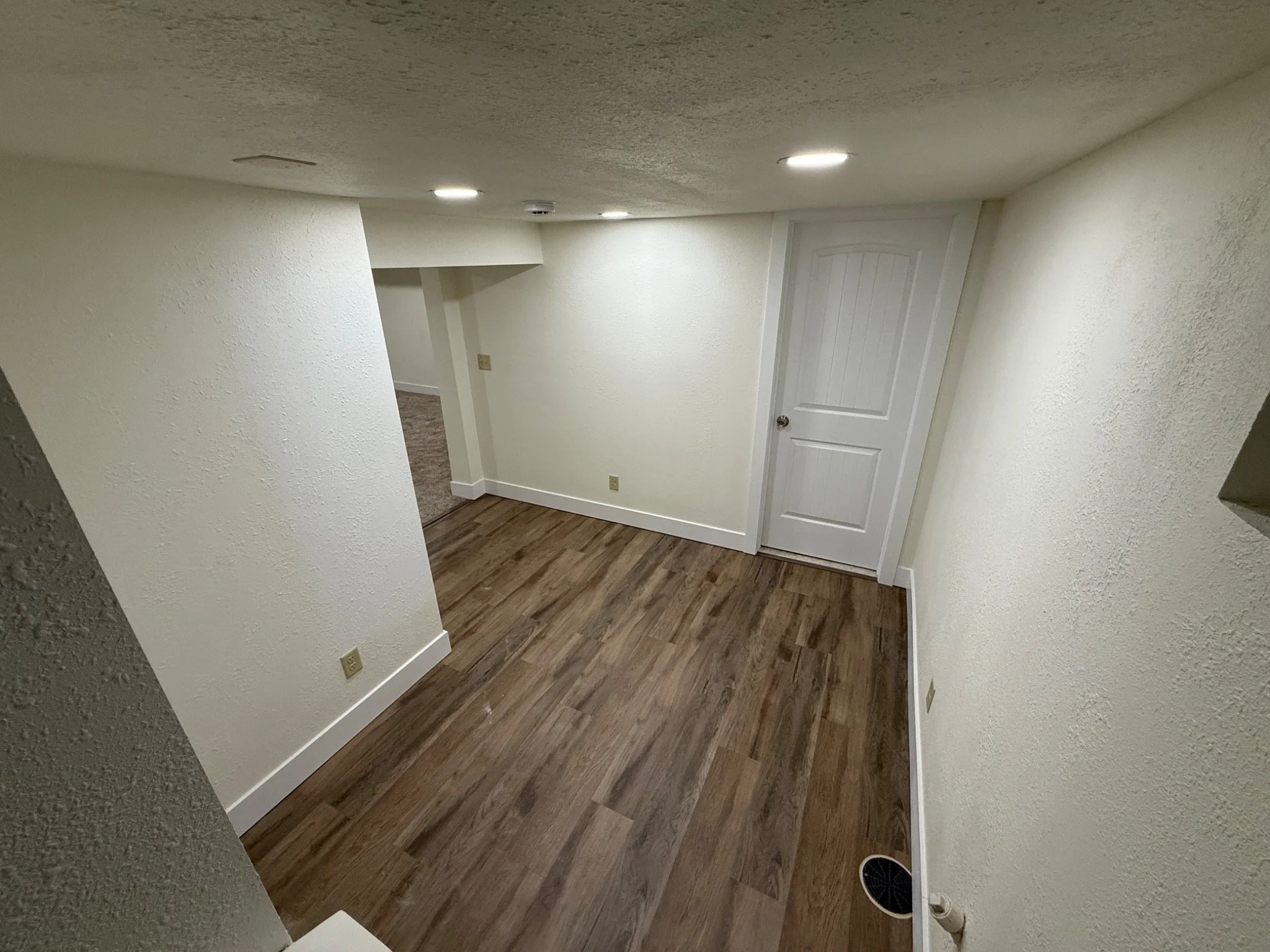 Reconstructed hallway with new flooring, painted walls, doors, and baseboards.