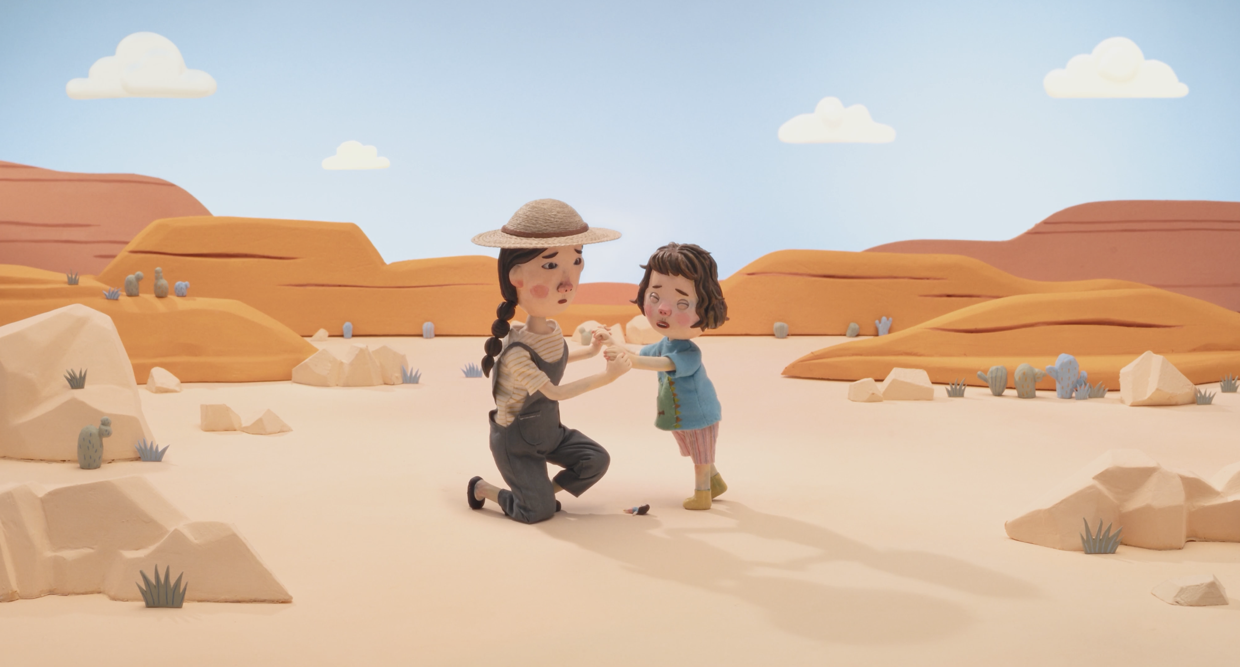 Claymation scene of two children in a desert landscape with orange rock formations, holding hands and appearing distressed or emotional.