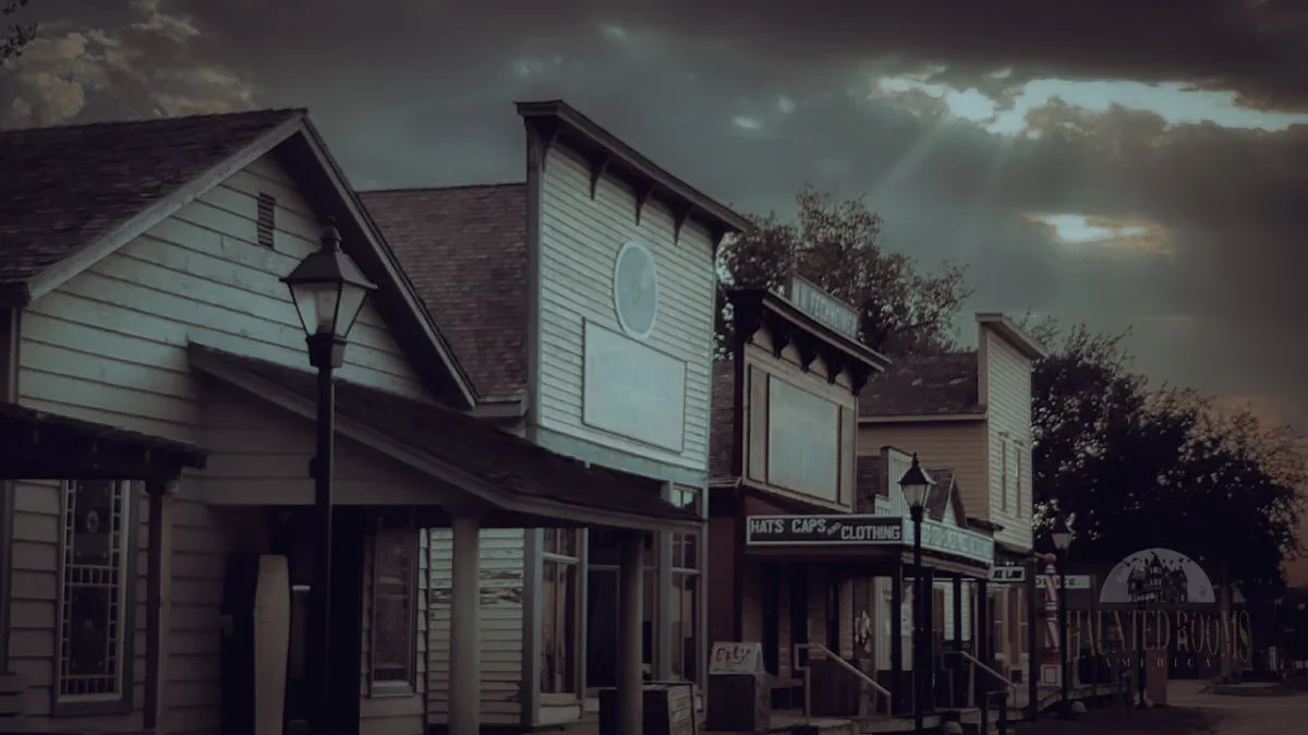 Ghost tours Cowtown in Wichita Kansas, Haunted by ghosts and things. Local Legends A row of small businesses with empty billboards and signs, under a cloudy sky with sunlight breaking through.