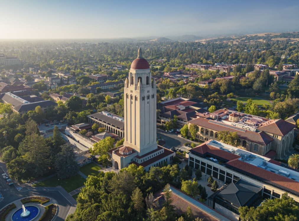 An aerial view of Stanford University in California, featuring the iconic Hoover Tower surrounded by campus buildings and greenery.