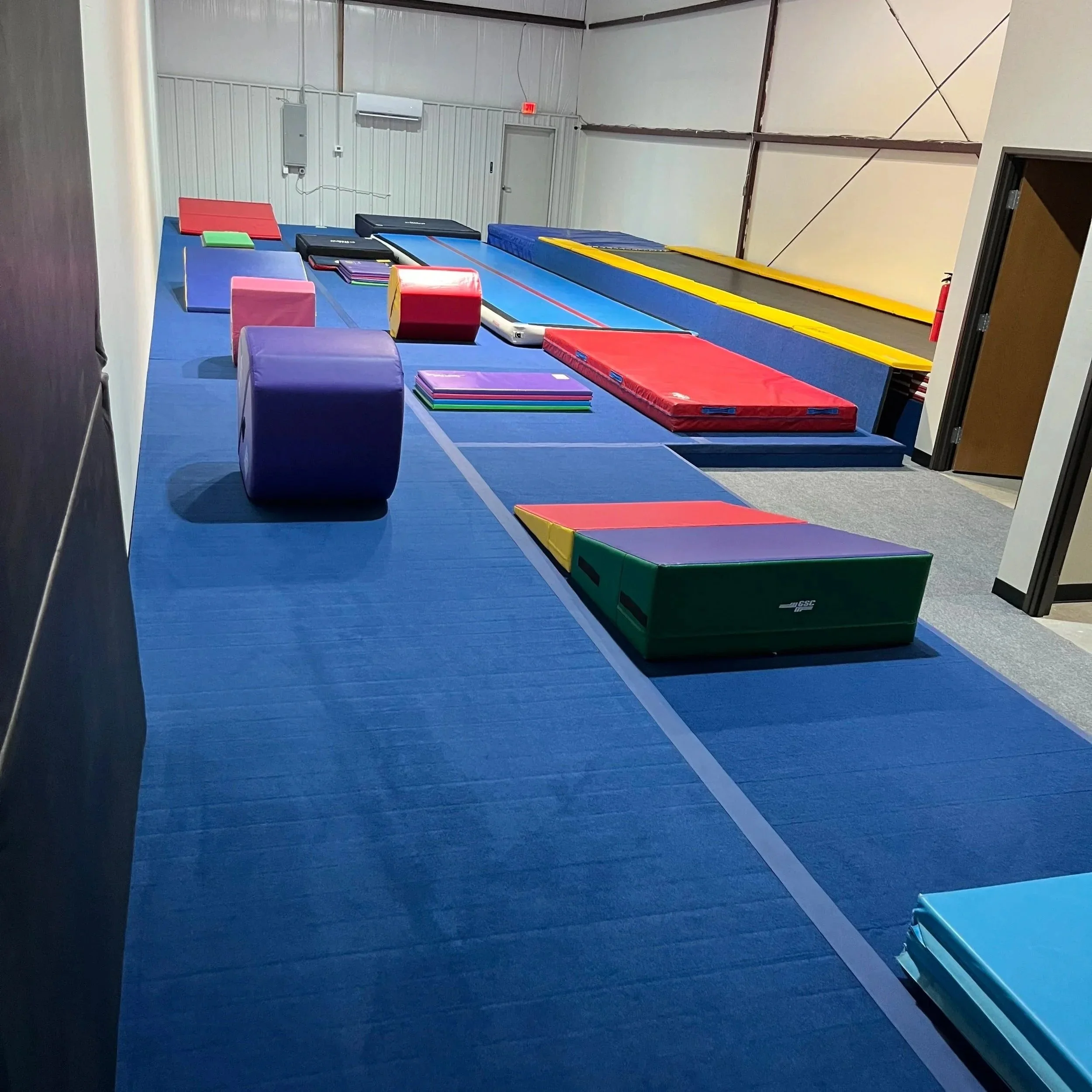 Inside the Flip'n Xperts tumbling gym in Northwest Oklahoma City, featuring a spring floor, tumble track, AirTrack, training mats, and tumbling equipment for athletes of all skill levels