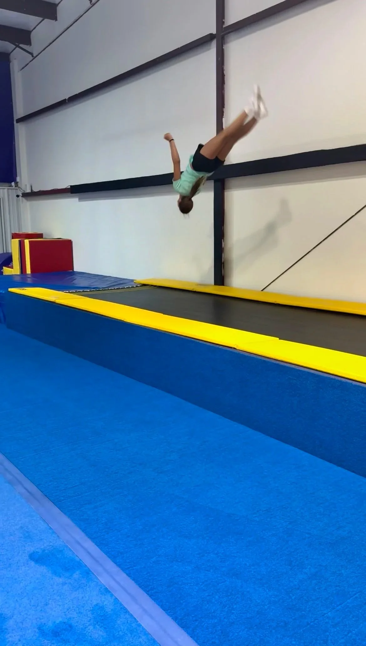 Athlete performing a layout on the tumble track at Flip'n Xperts in Northwest Oklahoma City during tumbling practice
