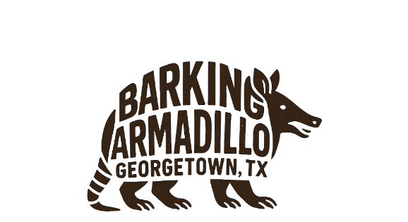 Black background with white and brown text promoting merchandise. The text says 'Check out our Merch!' and features a stylized armadillo with the words 'Barking Armadillo, Georgetown, TX' inside its body.