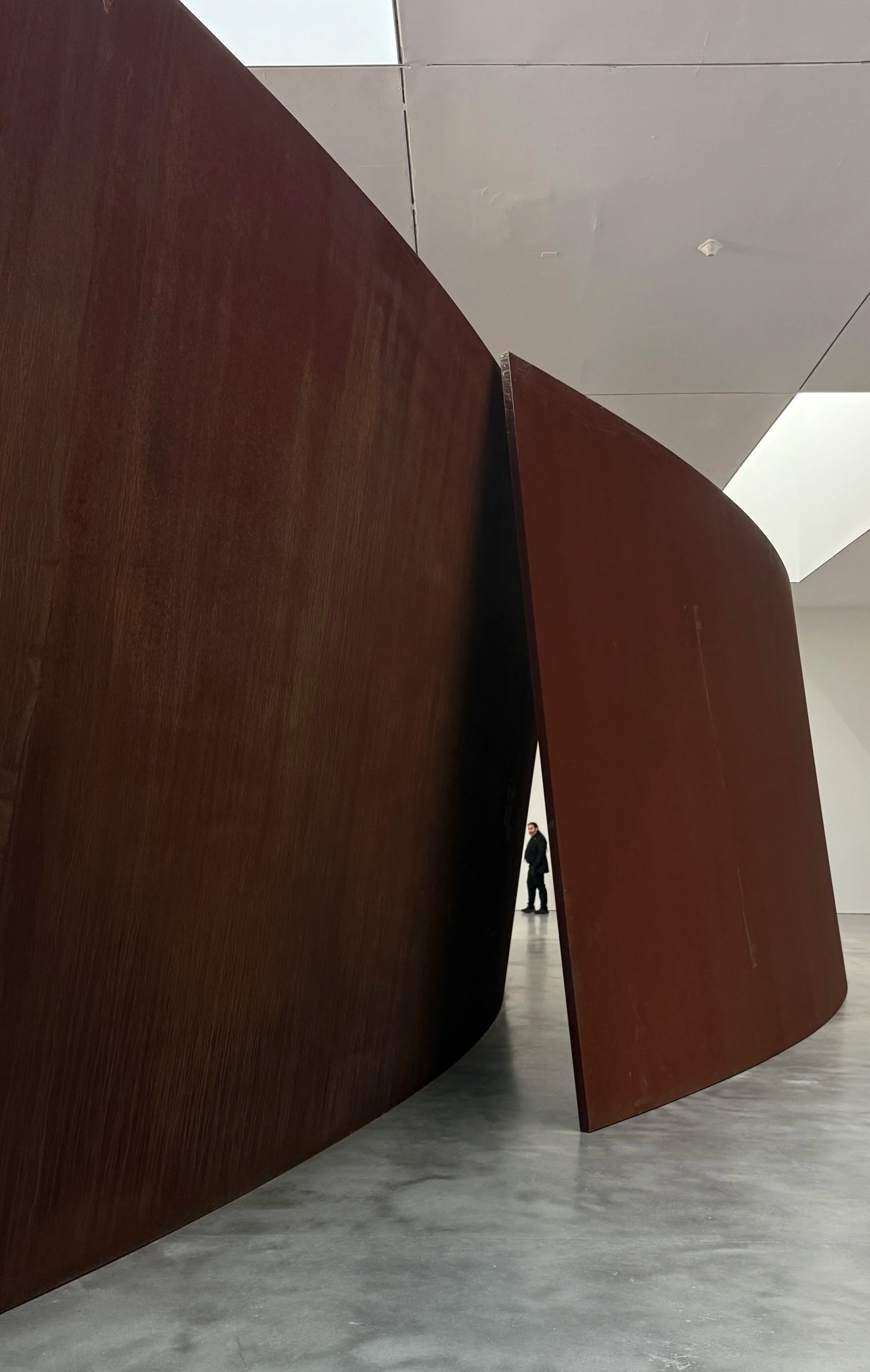 Richard Serra metal sculptures in Gagosian Gallery NY with a person standing in the background.