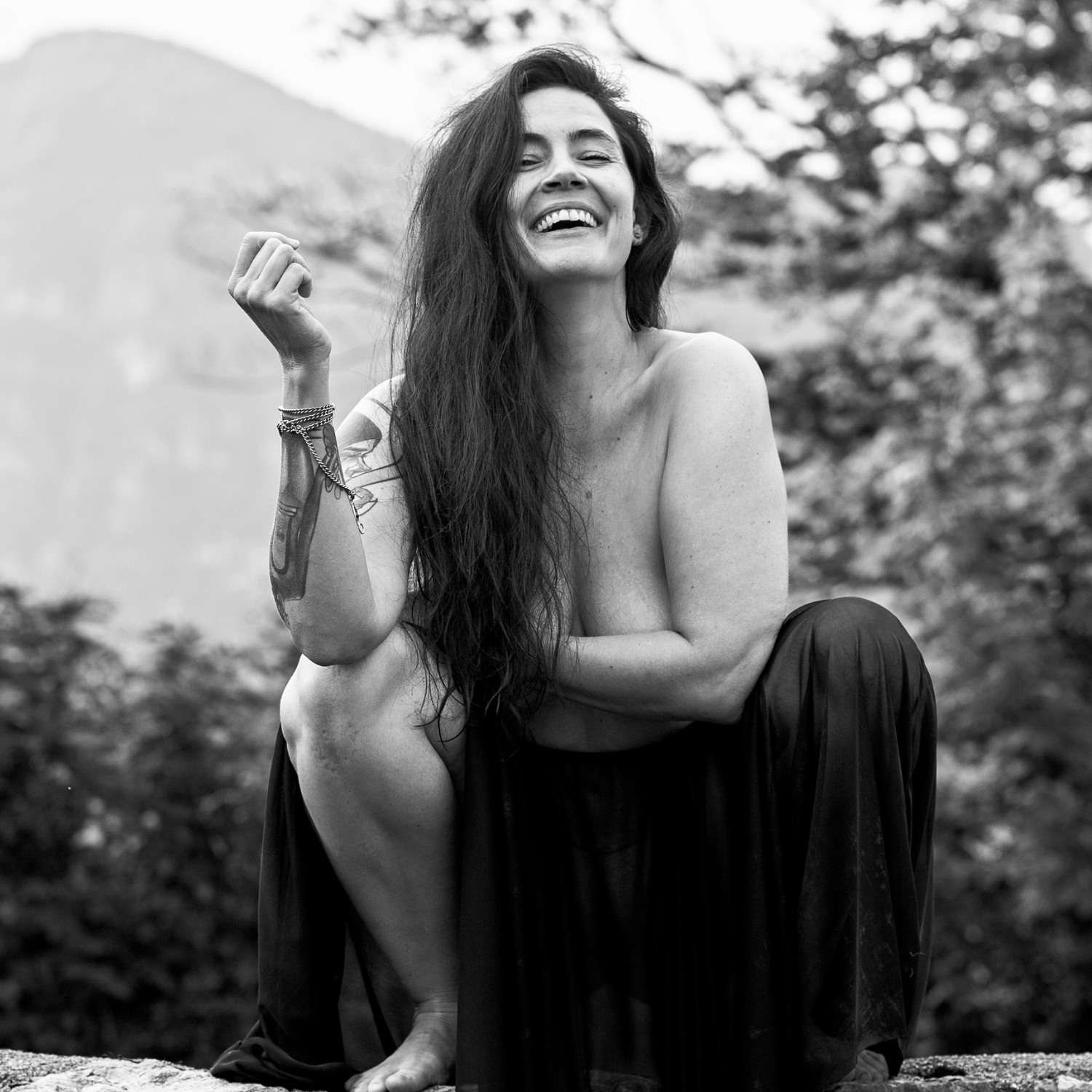 Girl smiling squatting on wall outside