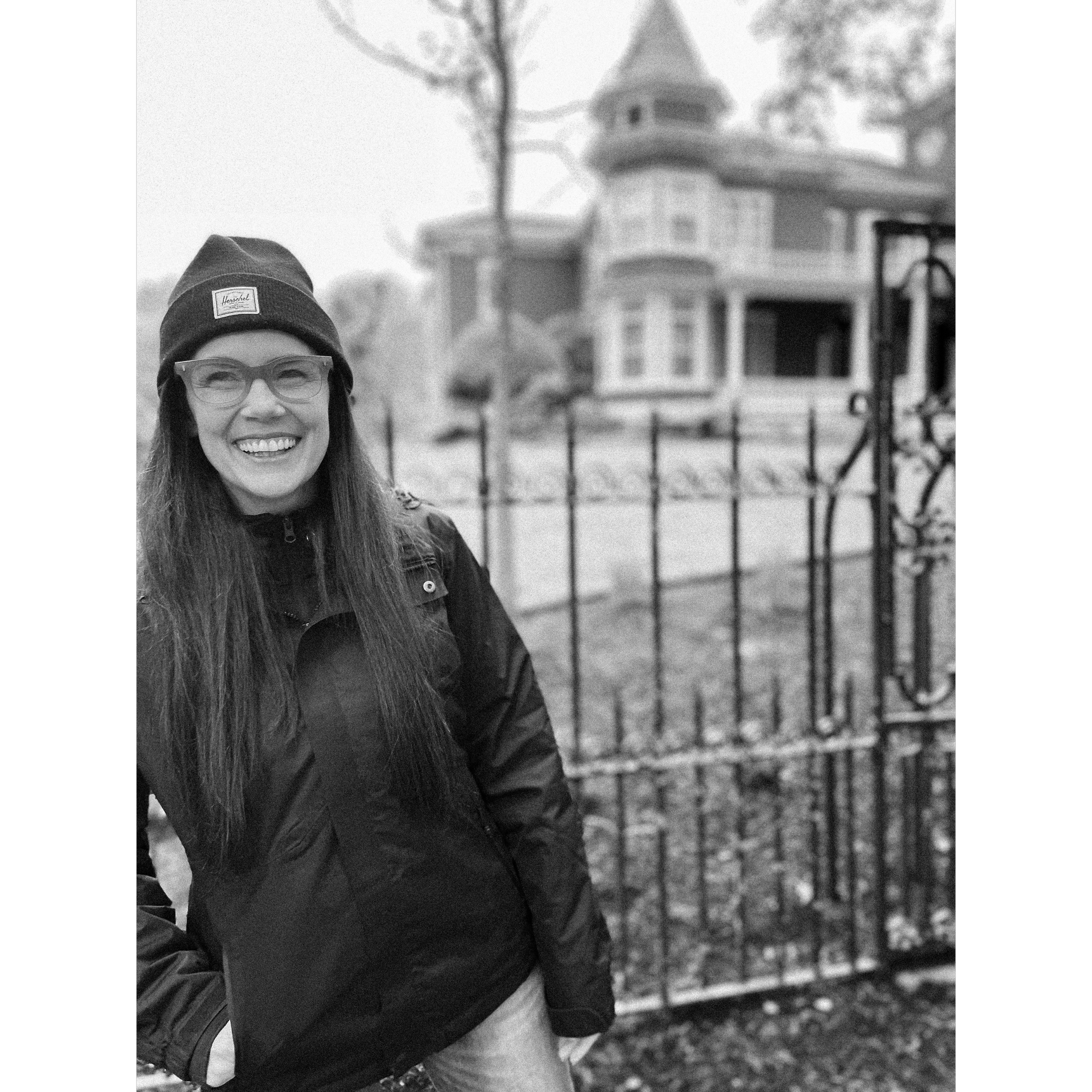 Girl smiles in front of Stephen King's house.