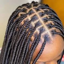 Close-up of a woman's head showing neatly styled box braids arranged in a precise pattern.
