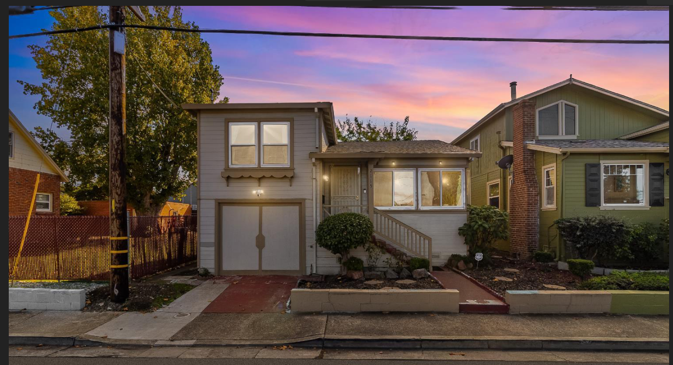 Front view of a house during sunset with a two-story structure, a staircase leading to the front door, a garage, and landscaped yard with bushes and a sidewalk.