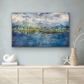 Abstract landscape painting of a lake and mountains hangs on a light-colored wall above a white sideboard with decorative objects.