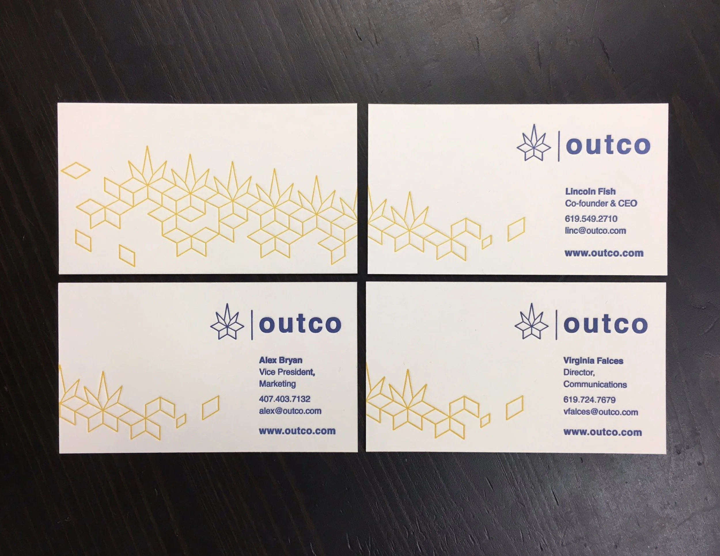 Business cards for Outco featuring a gold geometric design on a white background, with contact details including names, titles, phone numbers, emails, and website.