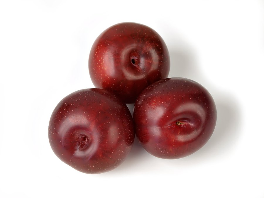 Three red plums on a white background.