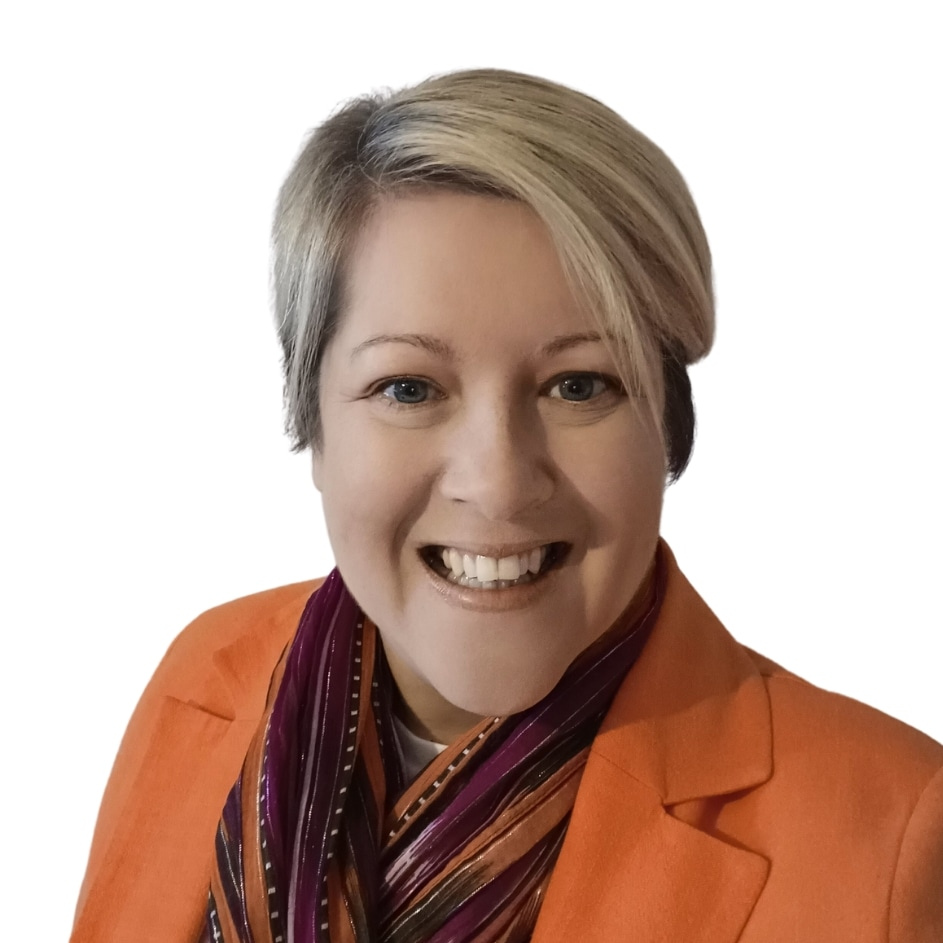A woman with short blonde hair smiling, wearing an orange blazer and a multicolored scarf, against a plain white background.