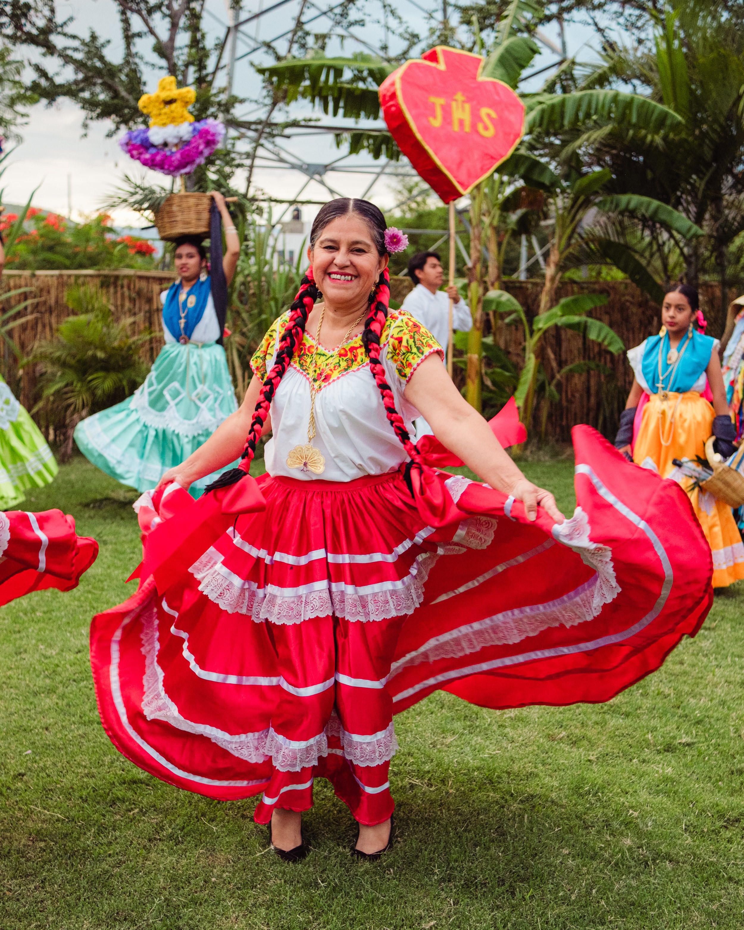 Traditional Oaxacan dancer in motion during a calenda parade, red skirt in full swing