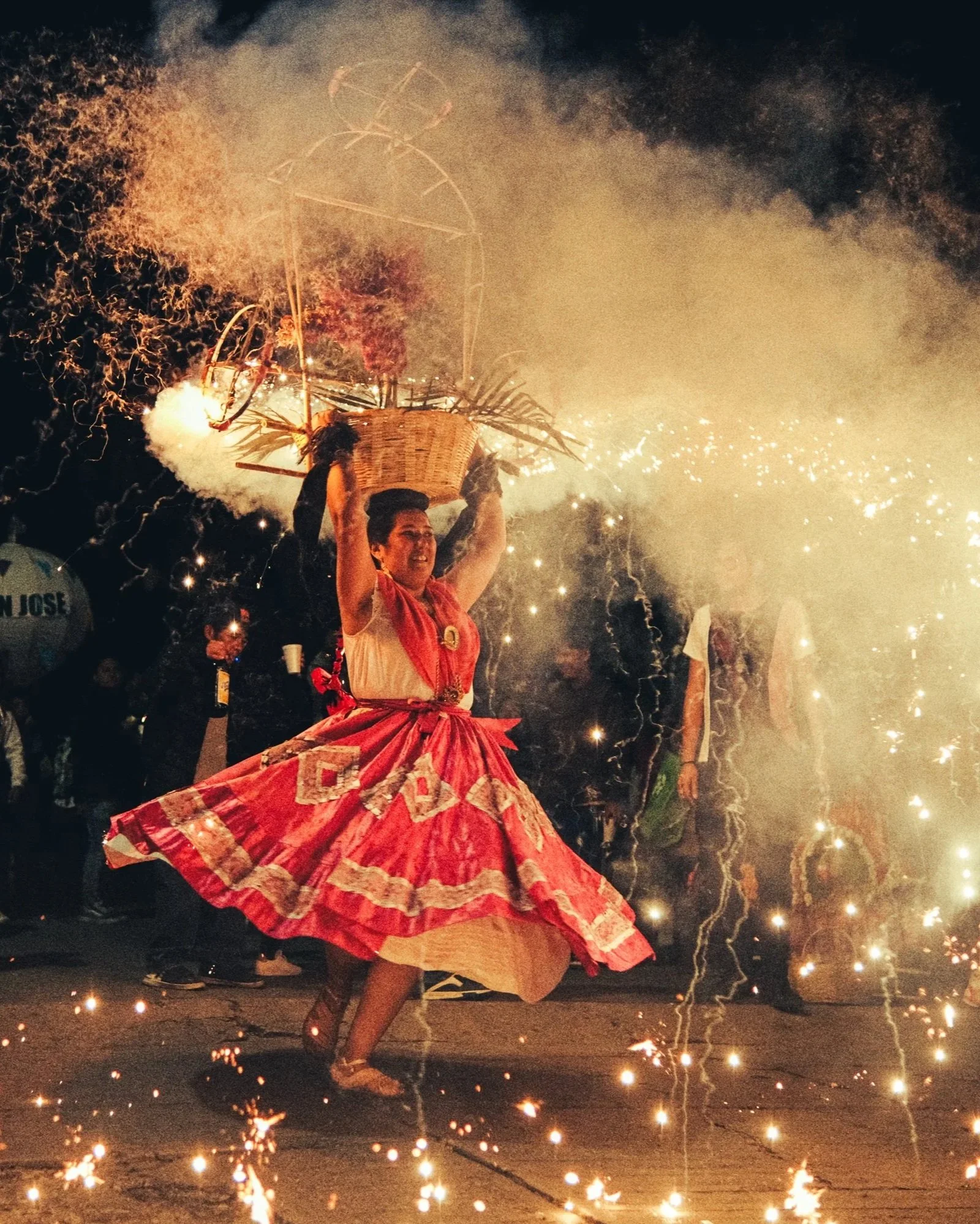 Oaxacan calenda dancer at night surrounded by traditional fireworks and sparks