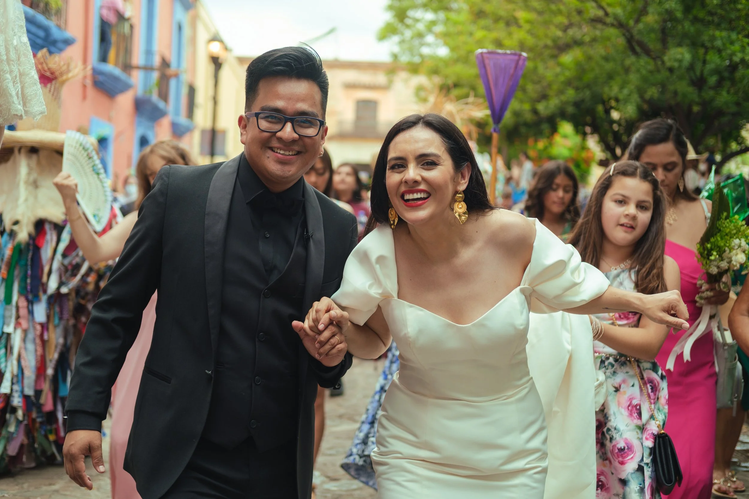 People joyfully holding hands at a wedding parade in oaxaca, mexico