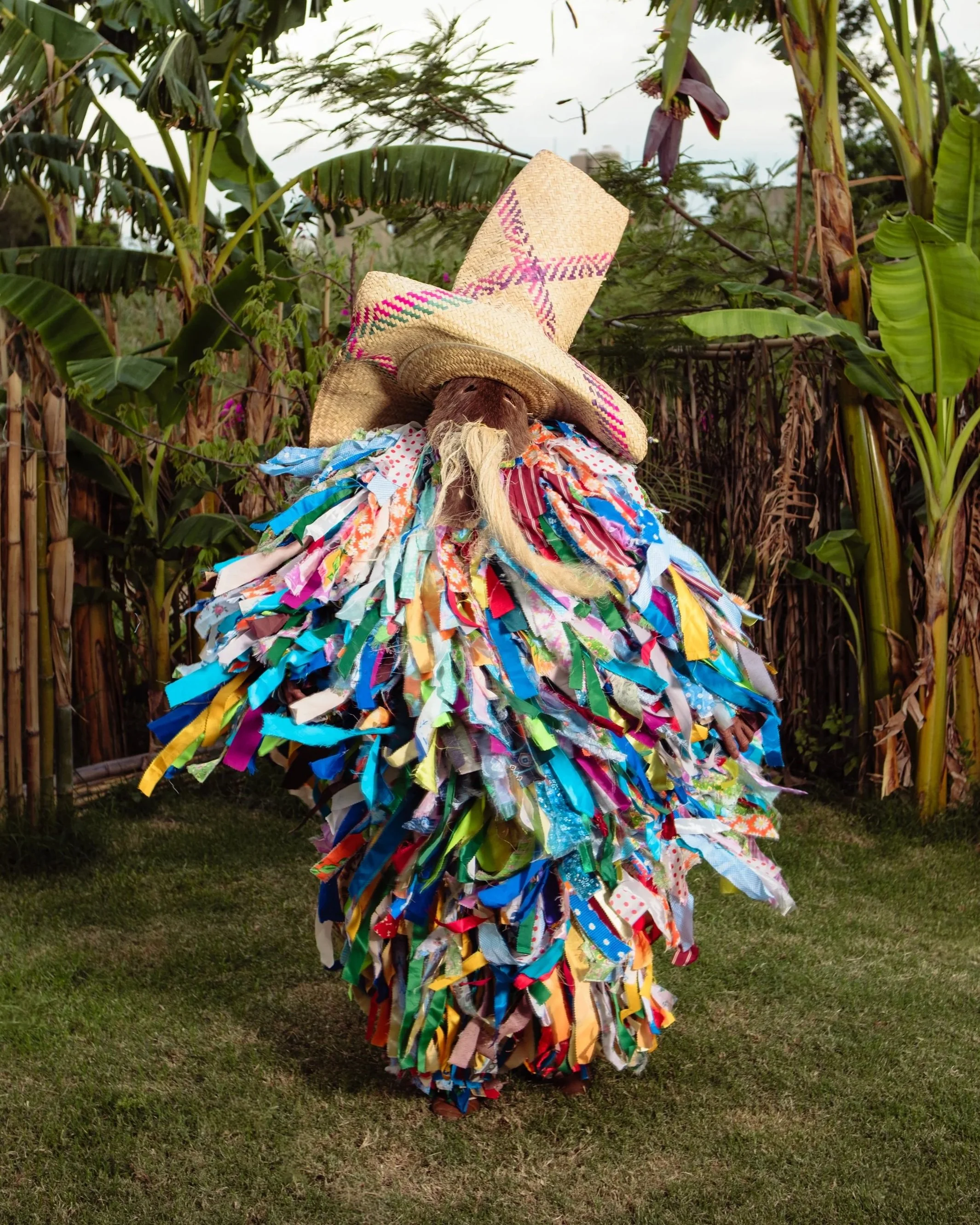 Traditional ribbon-costumed character (tiliche) performing in an Oaxacan calenda parade