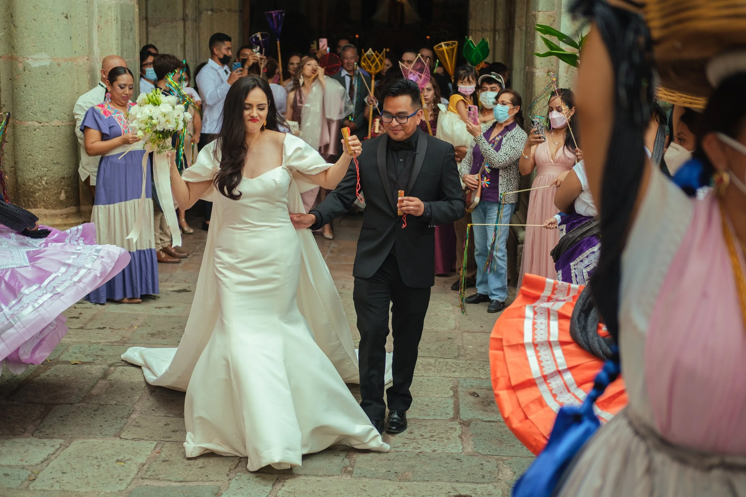 A bride and groom dancing in a traditional calenda parade in oaxacainside a historic church