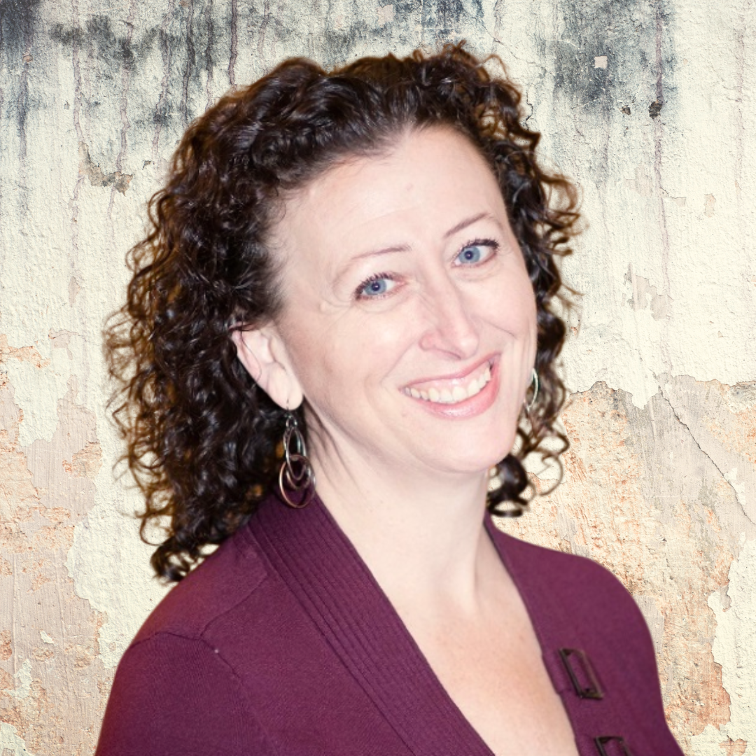 Kristi Keller smiling, in front of a textured wall background.