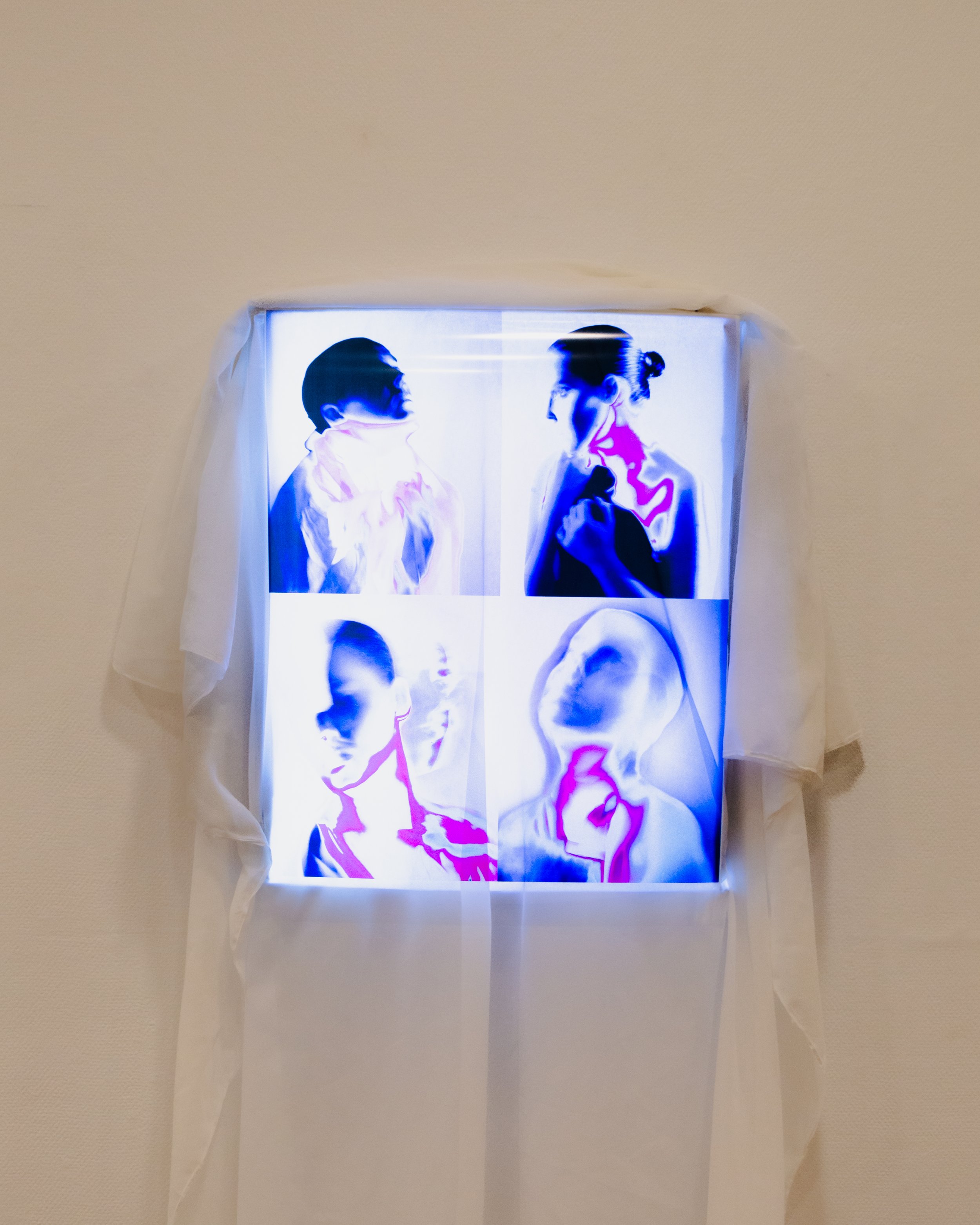 Photograph of two women facing each other, standing close with contrasting lighting, with digital effects creating an artistic, illuminated effect.